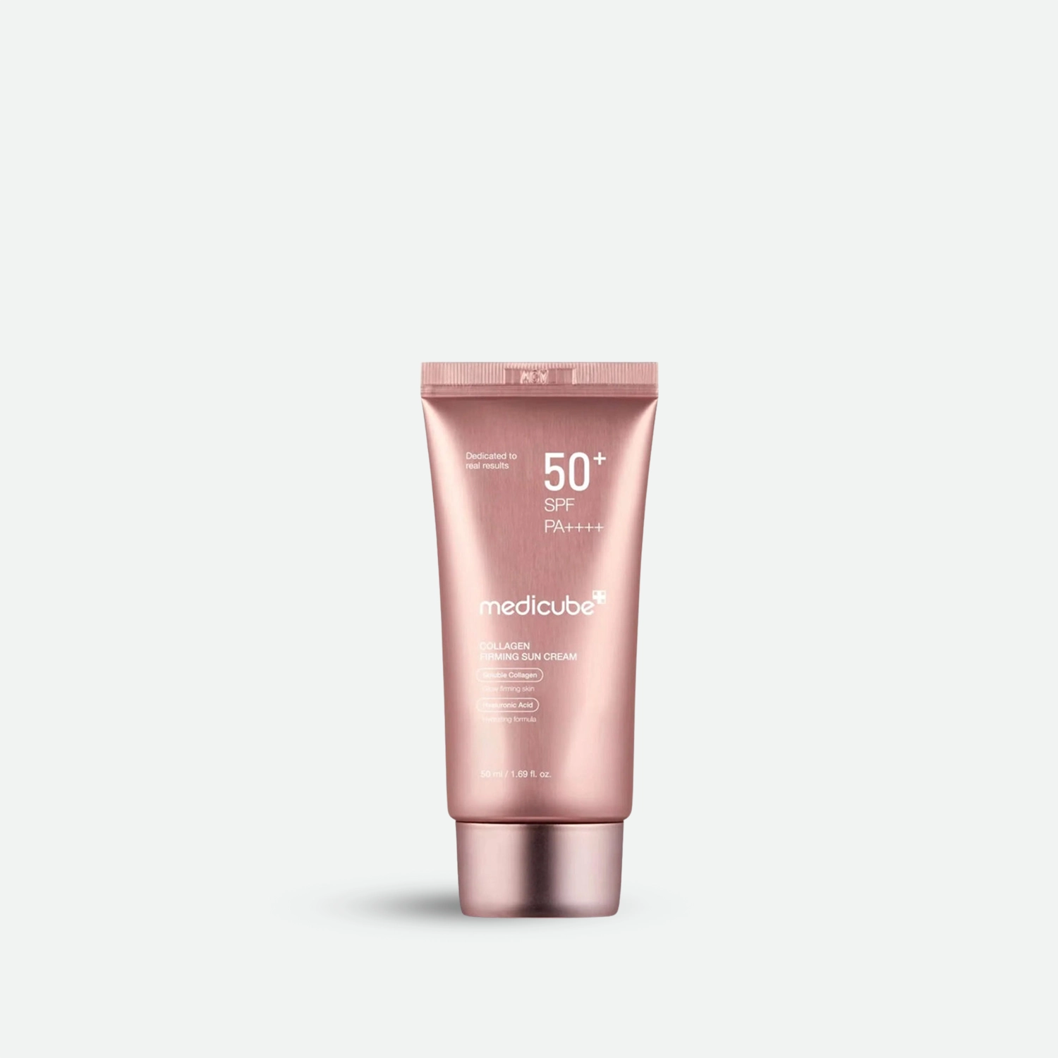 Pink sunscreen tube with SPF 50+ on a light gray background